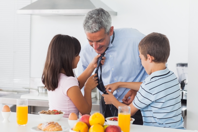 Children helping dad with a tie in the kitchen during breakfast